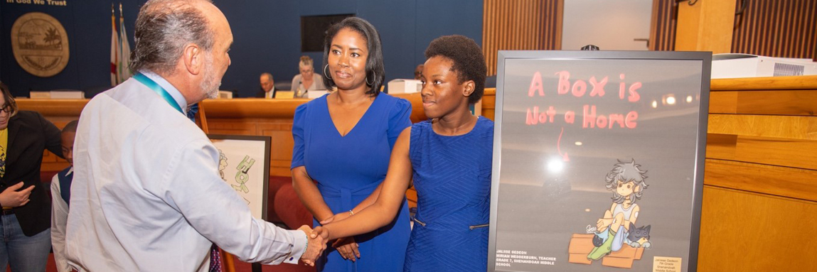 Student receiving an award at the Homeless Sensitivity Poster and Essay Contest